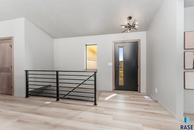 foyer entrance featuring light wood-type flooring and a notable chandelier