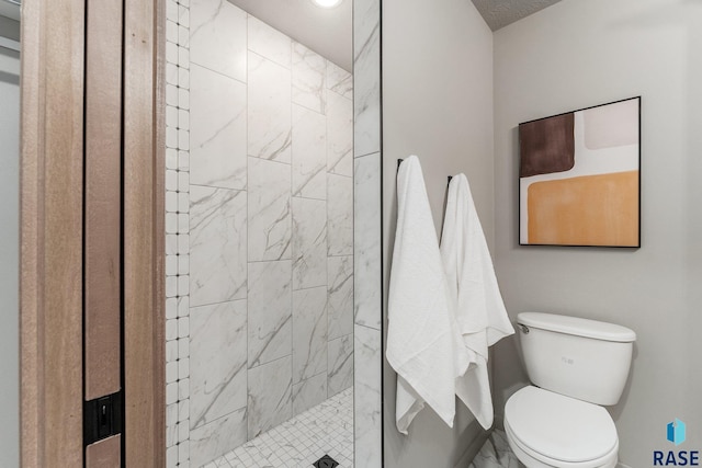 bathroom with toilet and tiled shower