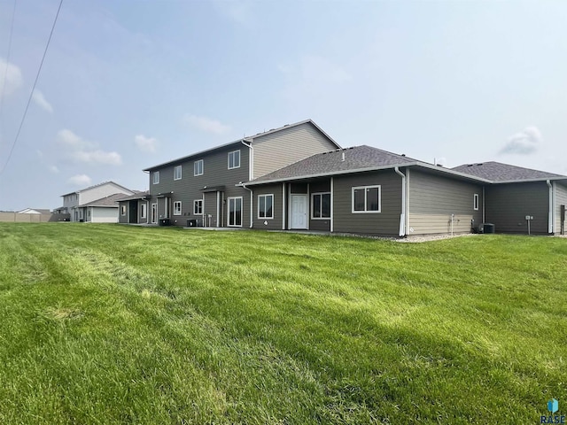 rear view of house with a yard and central AC unit