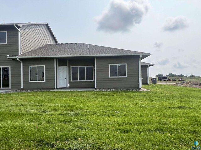 rear view of house featuring a lawn and a patio area