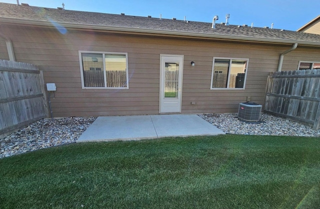 rear view of property with central AC and a lawn