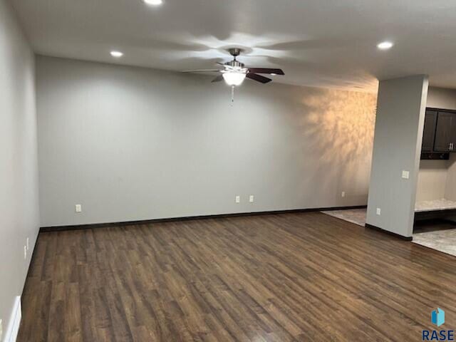 empty room with ceiling fan and dark hardwood / wood-style flooring