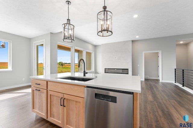 kitchen with light brown cabinetry, stainless steel dishwasher, a sink, and a healthy amount of sunlight