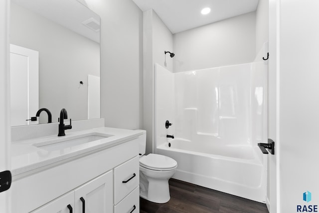 full bath with toilet, wood finished floors, vanity, visible vents, and shower / washtub combination