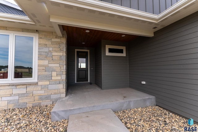 property entrance with stone siding and board and batten siding