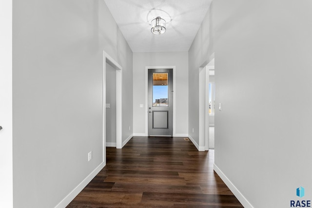 interior space featuring baseboards and dark wood-style flooring