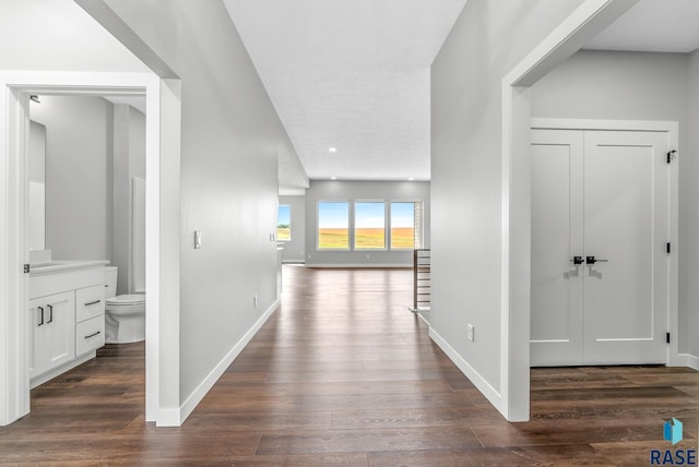 hall with dark wood-style floors and baseboards