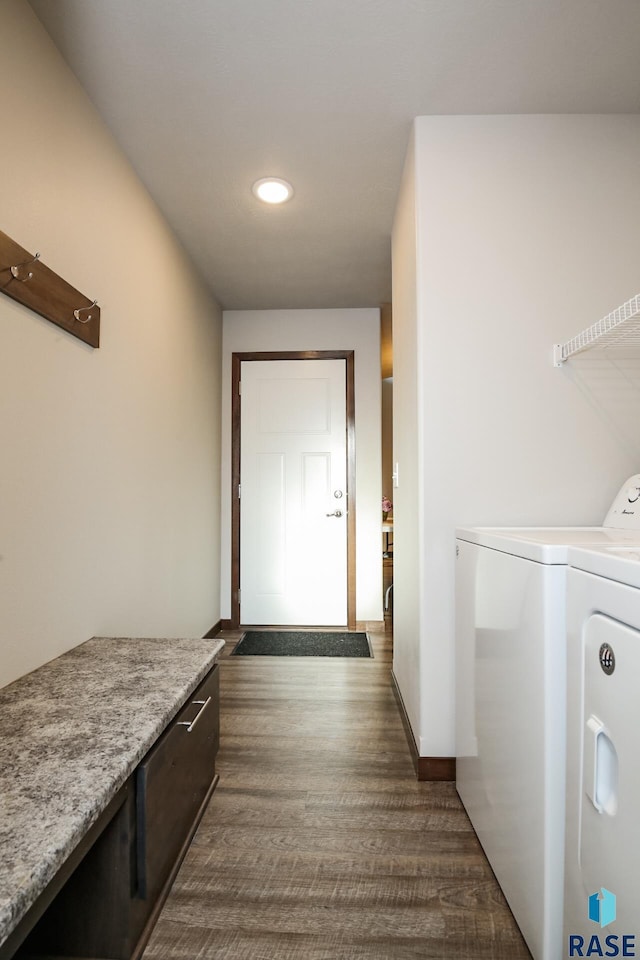 laundry room with dark wood-type flooring and washer and dryer