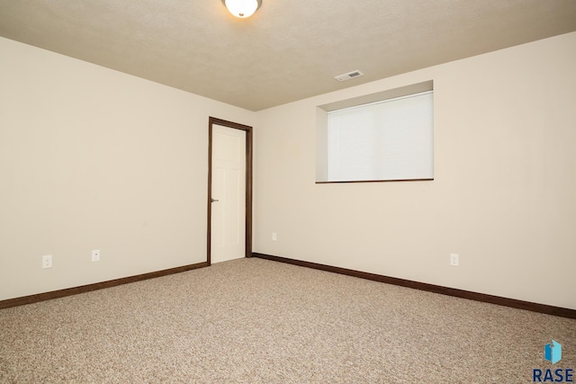 spare room with carpet flooring and a textured ceiling