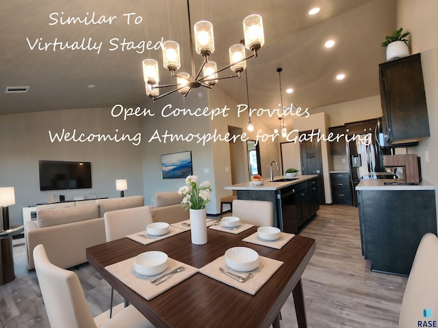 dining room featuring recessed lighting, visible vents, vaulted ceiling, light wood-type flooring, and an inviting chandelier