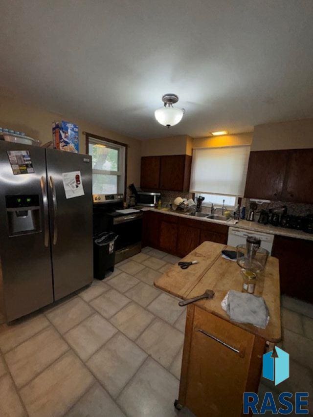 kitchen with light tile patterned floors, white dishwasher, range with electric cooktop, and fridge with ice dispenser