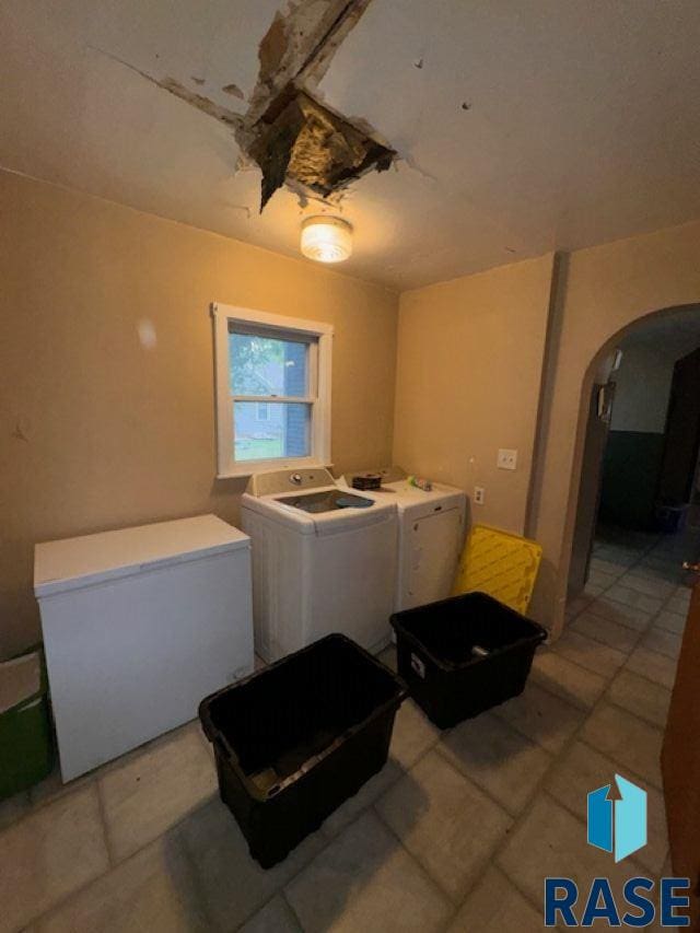 kitchen featuring fridge, light tile patterned floors, and independent washer and dryer