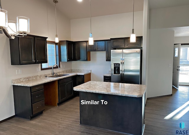 kitchen featuring hanging light fixtures, sink, stainless steel fridge with ice dispenser, and a center island