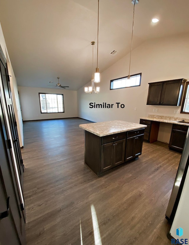 kitchen featuring vaulted ceiling, pendant lighting, a center island, dark brown cabinetry, and dark wood-type flooring