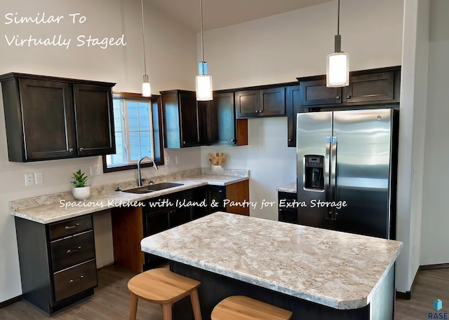 kitchen with stainless steel fridge with ice dispenser, dark brown cabinets, a sink, and a center island