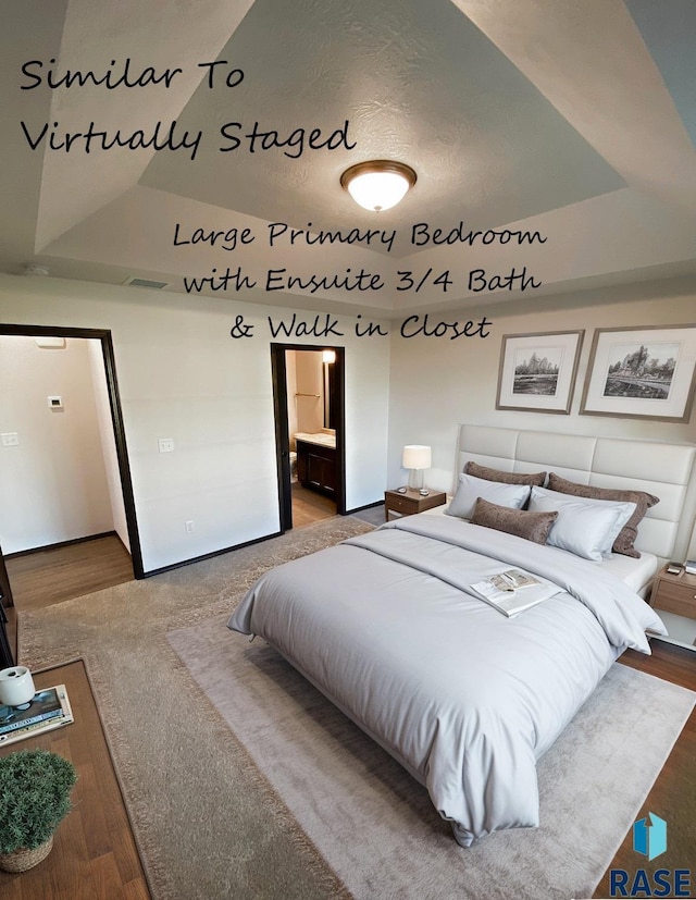bedroom featuring a tray ceiling and ensuite bathroom