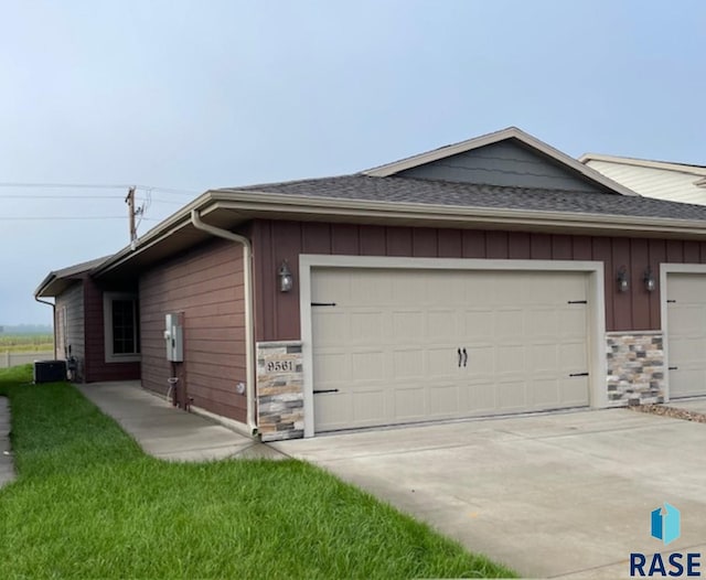 view of side of property featuring central AC unit and a garage