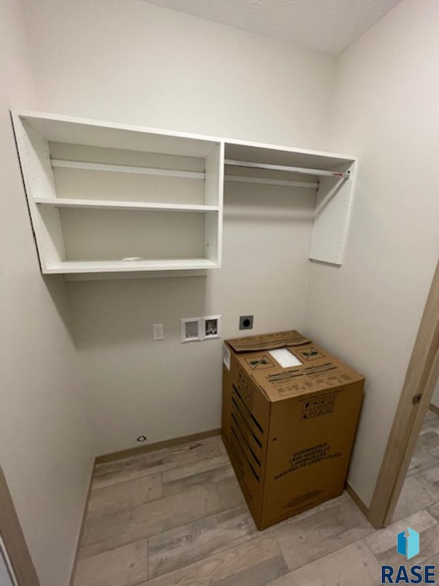 washroom featuring hookup for a washing machine, hookup for an electric dryer, and light hardwood / wood-style floors