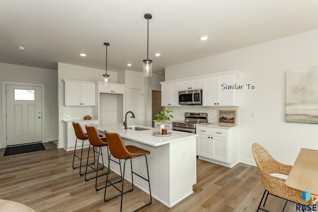 6513 S Barclay Trl, Sioux Falls, SD 57106 - kitchen featuring stainless steel appliances, a sink, tasteful backsplash, light wood finished floors, and recessed lighting