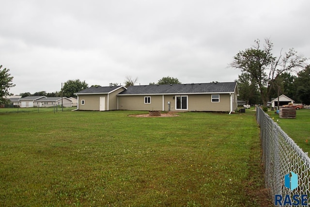 back of house with fence and a lawn