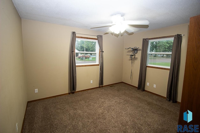 empty room featuring carpet floors, ceiling fan, baseboards, and a textured ceiling