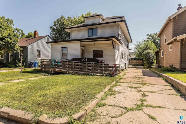 traditional style home featuring a deck and a front yard