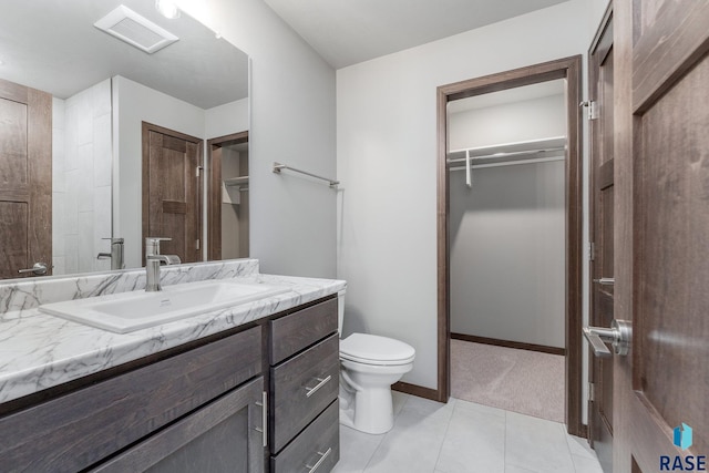 bathroom featuring tile patterned flooring, toilet, and vanity