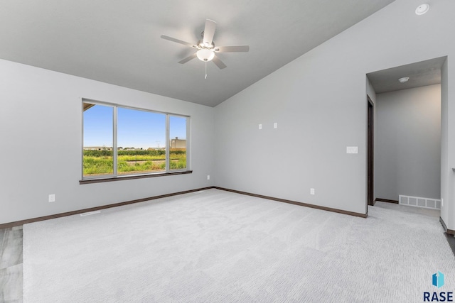 carpeted spare room with ceiling fan and lofted ceiling