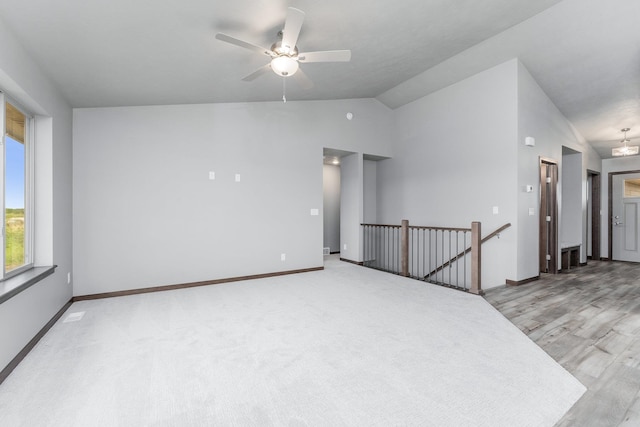 unfurnished room featuring ceiling fan, light carpet, and lofted ceiling