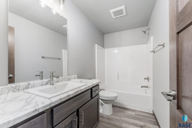 full bathroom featuring toilet, washtub / shower combination, vanity, and wood-type flooring