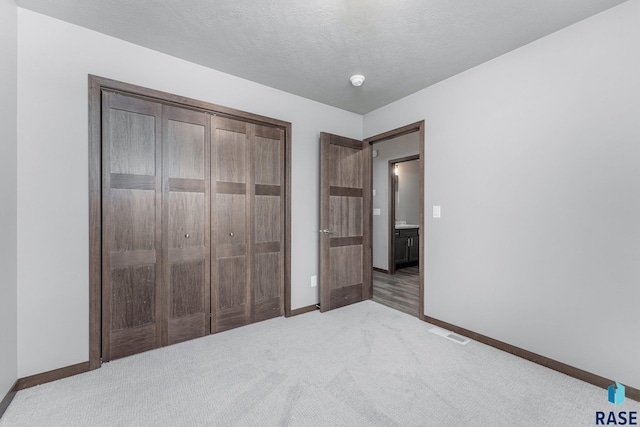 unfurnished bedroom featuring a closet and light carpet