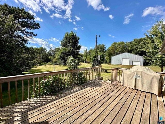 wooden deck featuring a yard, a garage, and an outdoor structure