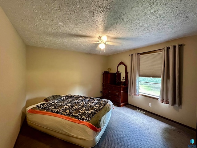 carpeted bedroom featuring ceiling fan and a textured ceiling