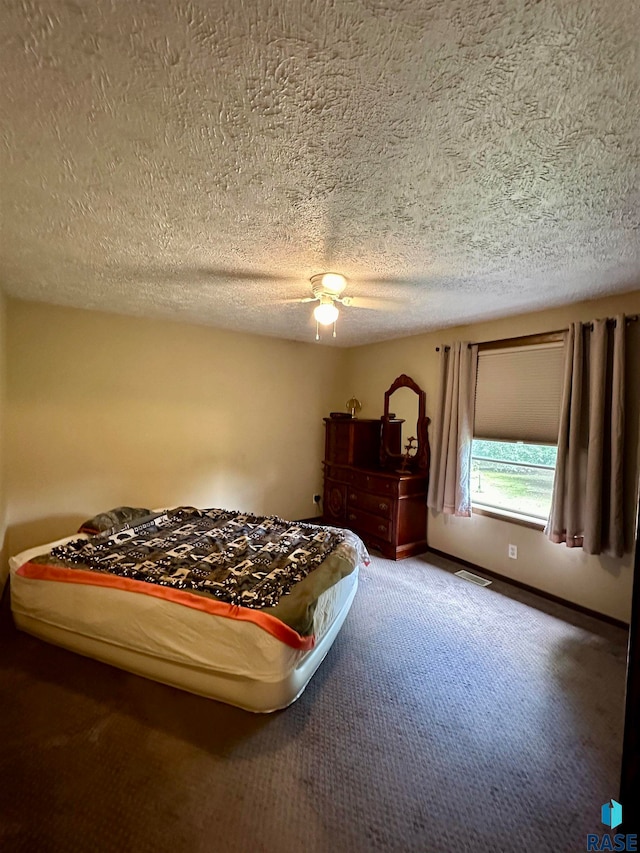 carpeted bedroom with a textured ceiling and ceiling fan