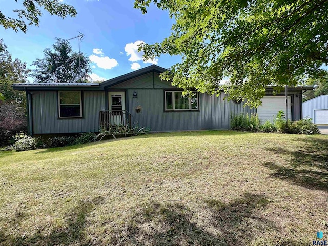 back of house with a lawn and a garage