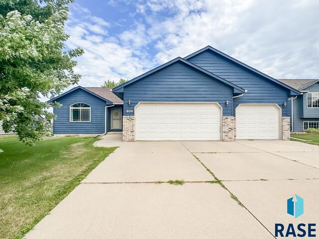 ranch-style house with a garage and a front lawn