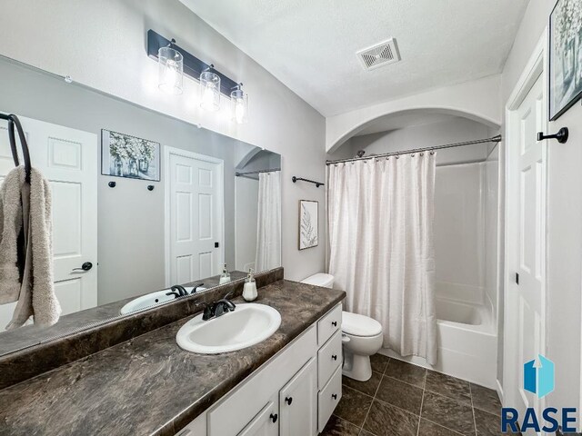 full bathroom featuring tile patterned floors, toilet, shower / tub combo with curtain, and vanity