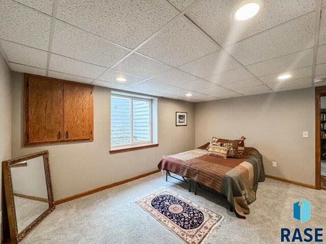 bedroom with light colored carpet and a paneled ceiling