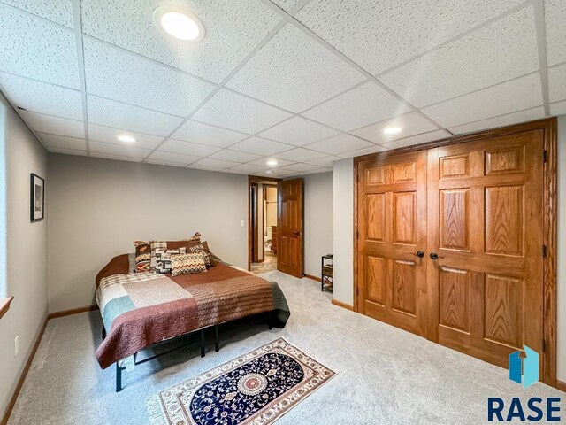 carpeted bedroom with a paneled ceiling