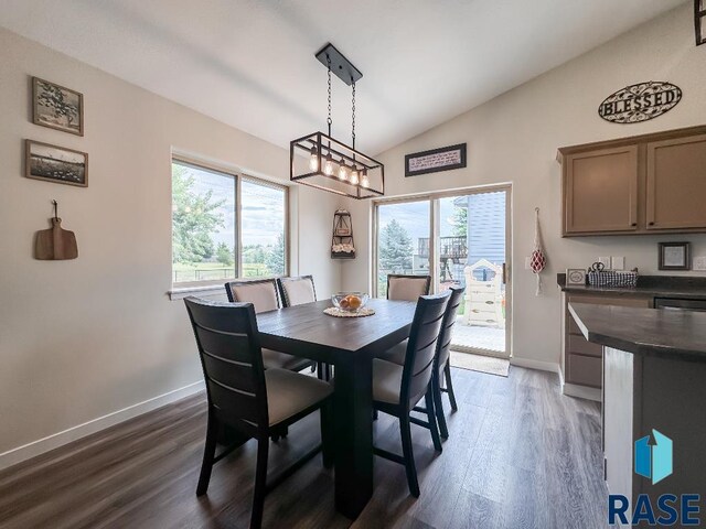 dining area featuring a notable chandelier, vaulted ceiling, and dark hardwood / wood-style floors