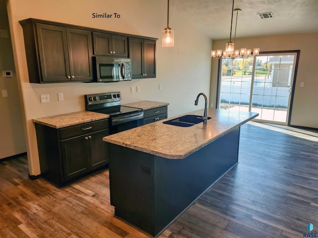 kitchen with sink, hanging light fixtures, stainless steel appliances, and a kitchen island with sink