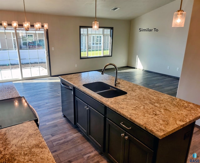 kitchen with a center island with sink, dark hardwood / wood-style floors, decorative light fixtures, stainless steel dishwasher, and sink