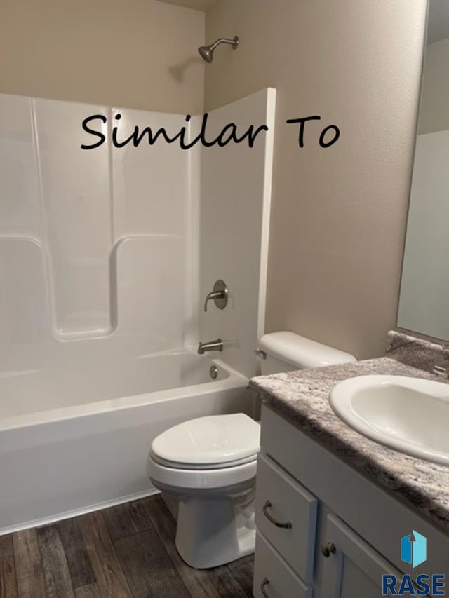 full bathroom with toilet, bathing tub / shower combination, hardwood / wood-style floors, and vanity