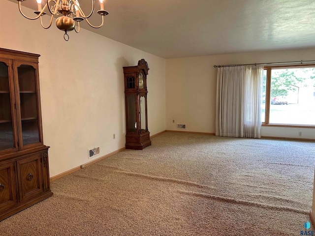 carpeted empty room with a chandelier