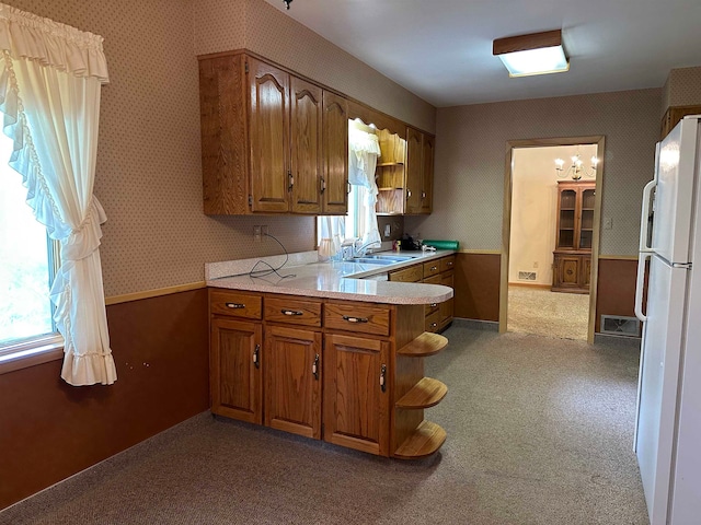 kitchen featuring sink, light colored carpet, a healthy amount of sunlight, and white fridge