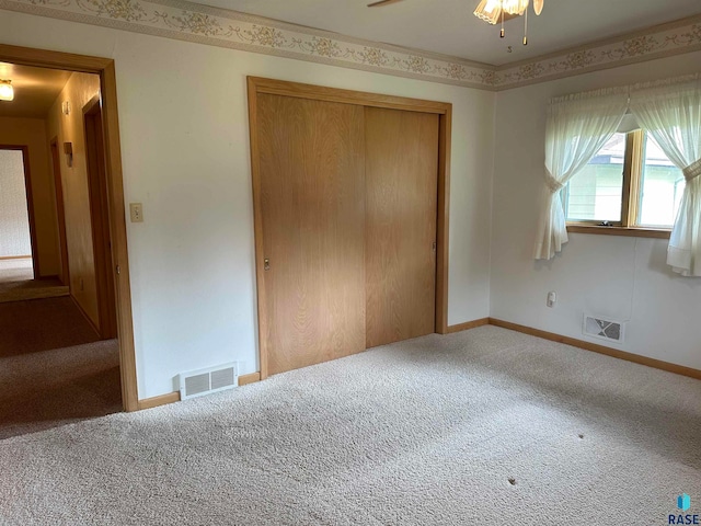 unfurnished bedroom with ceiling fan, a closet, and carpet