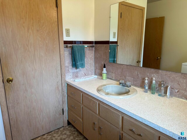 bathroom featuring tile patterned floors, toilet, backsplash, and vanity