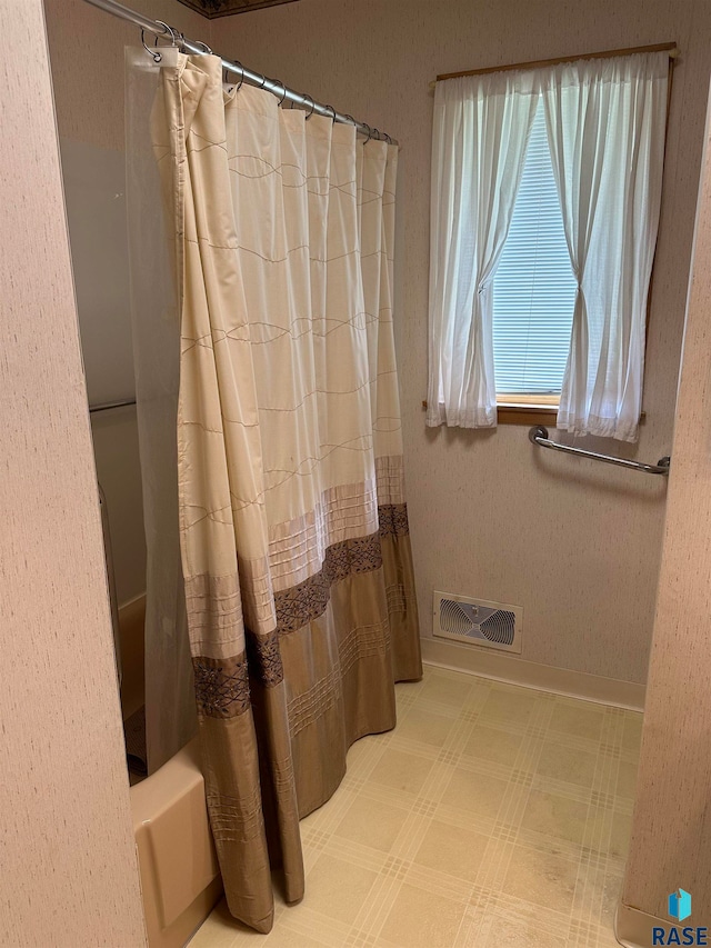 bathroom with tile patterned flooring and shower / bath combo