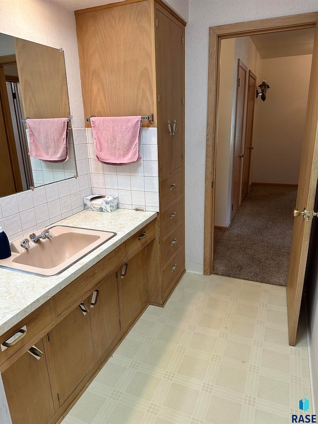 bathroom with tile patterned flooring, vanity, and tasteful backsplash