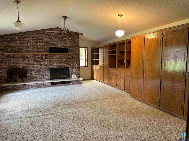 unfurnished living room featuring a brick fireplace, a textured ceiling, brick wall, light colored carpet, and lofted ceiling